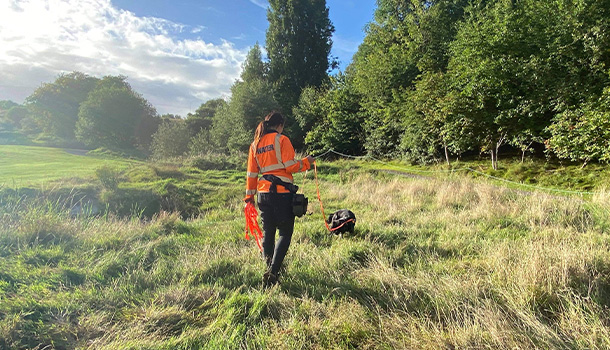 Employee walking freya the newt dog in a field